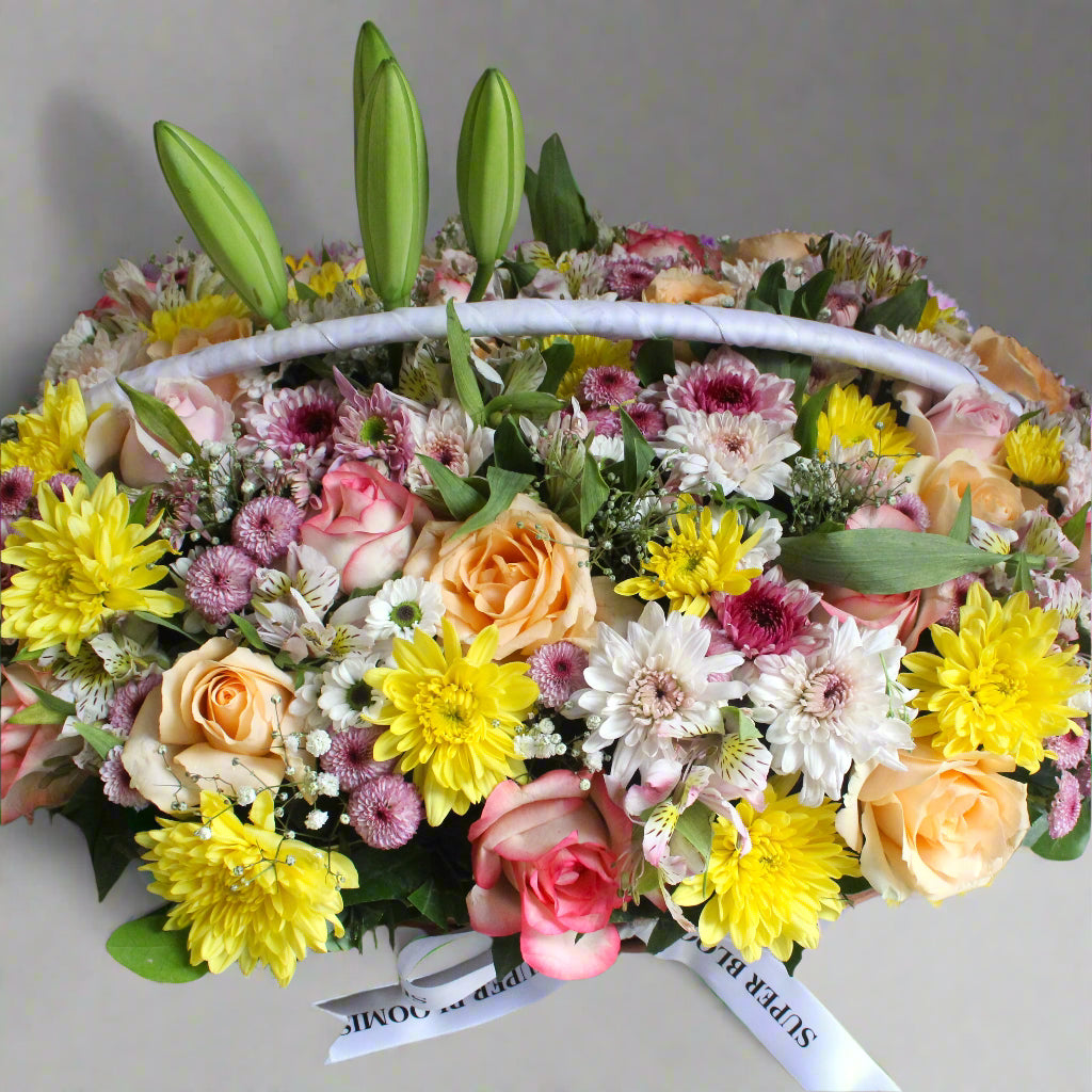 The bright yellow daisies and soft pinks of the roses, daisies, and Lisianthus create a harmonious balance, while the gypso adds a delicate touch to this cheerful arrangement.