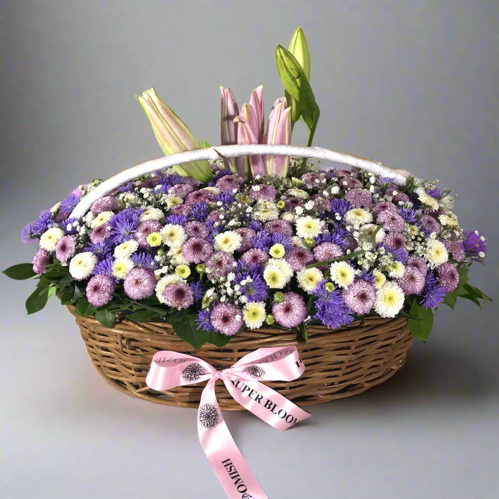 The delicate white buttons and soft pink accents blend with vibrant blue daisies, creating a serene and joyful arrangement. The subtle elegance of the lily adds a touch of grace.