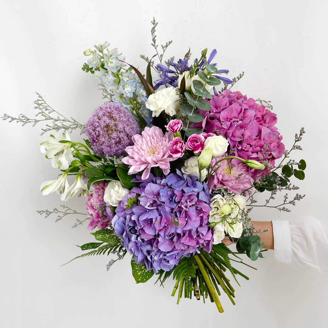 A soft and sophisticated blend of hydrangeas, carnations, eustoma (lisianthus), and orchids, this bouquet whispers elegance with every petal. Its delicate textures and graceful tones make it perfect for heartfelt celebrations or serene, thoughtful gifting.