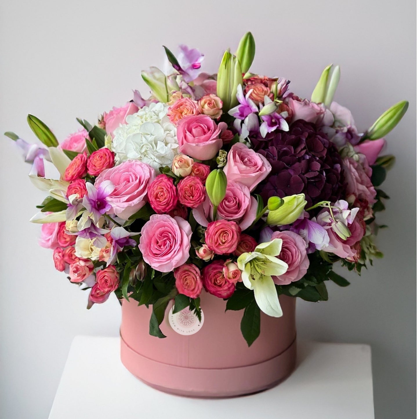 A luxurious bouquet featuring the timeless beauty of roses, the elegance of lilies, the fullness of hydrangeas, and the delicacy of eustomas. This arrangement exudes sophistication and charm, perfect for adding a touch of grace to any occasion.