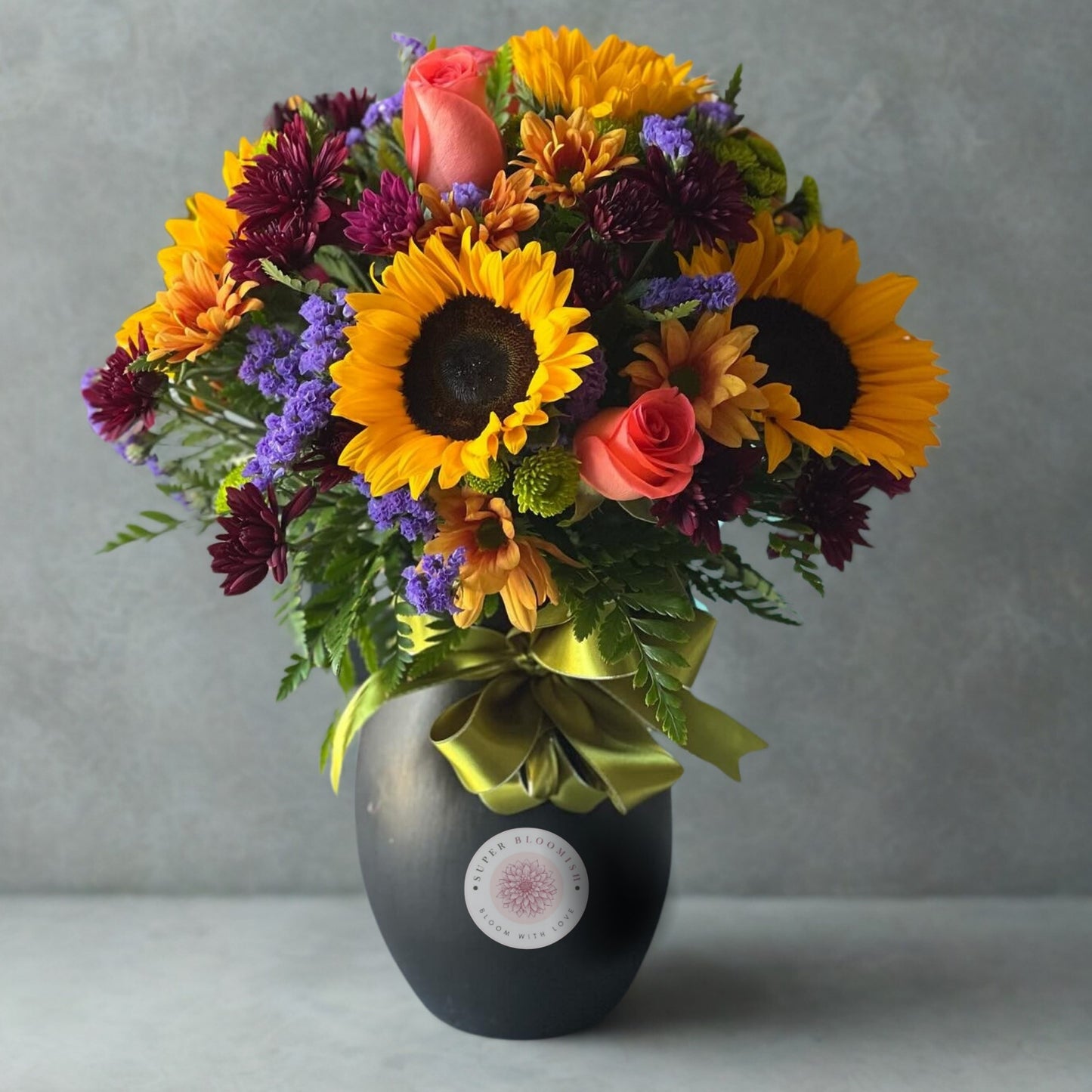 A radiant combination of roses, sunflowers, stock flowers, lisianthus (eustoma), and carnations, beautifully accented with lush green leaves. This bouquet captures the essence of warmth, elegance, and charm, making it a perfect gift to brighten any occasion.