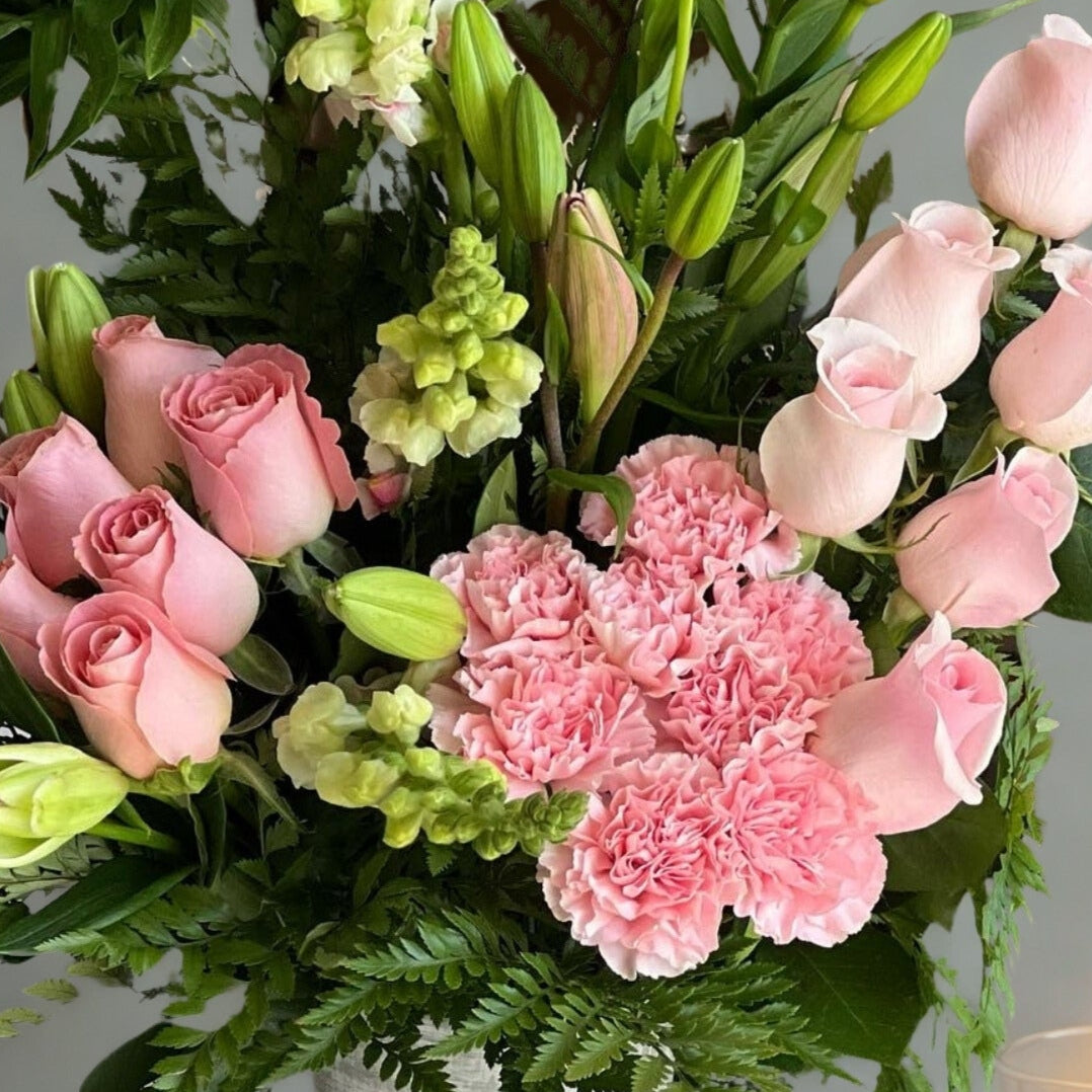 A captivating mix of roses, lilies, and carnations, accented with lush green fillers and foliage. This elegant arrangement blends soft textures and vibrant blooms, creating a timeless expression of love, joy, and beauty—perfect for any occasion