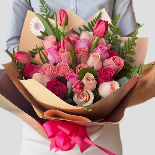 A delicate and elegant blend of tulips and roses in soft pink hues, this arrangement exudes grace, charm, and romance. The gentle curves of tulips complement the classic beauty of roses, creating a bouquet perfect for any heartfelt occasion.