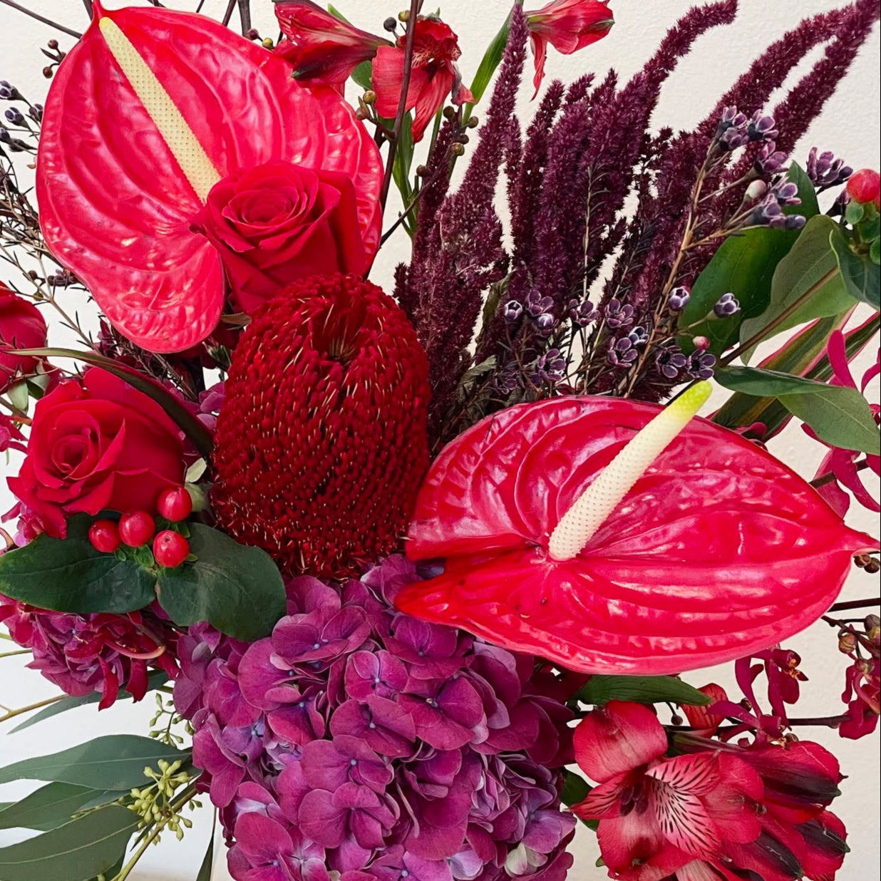 A bold and romantic arrangement featuring hydrangeas, anthuriums, wax flowers, and stock flowers in passionate red tones. With its rich texture and dramatic flair, this bouquet speaks the language of love with elegance and intensity—perfect for unforgettable moments.