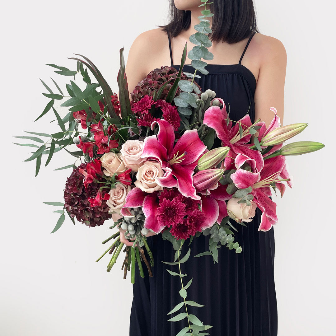 A rich and romantic arrangement in passionate red tones, featuring lilies, red hydrangeas, roses, carnations, and daisies. This bouquet speaks the language of love and intensity, making it perfect for grand gestures and unforgettable celebrations.