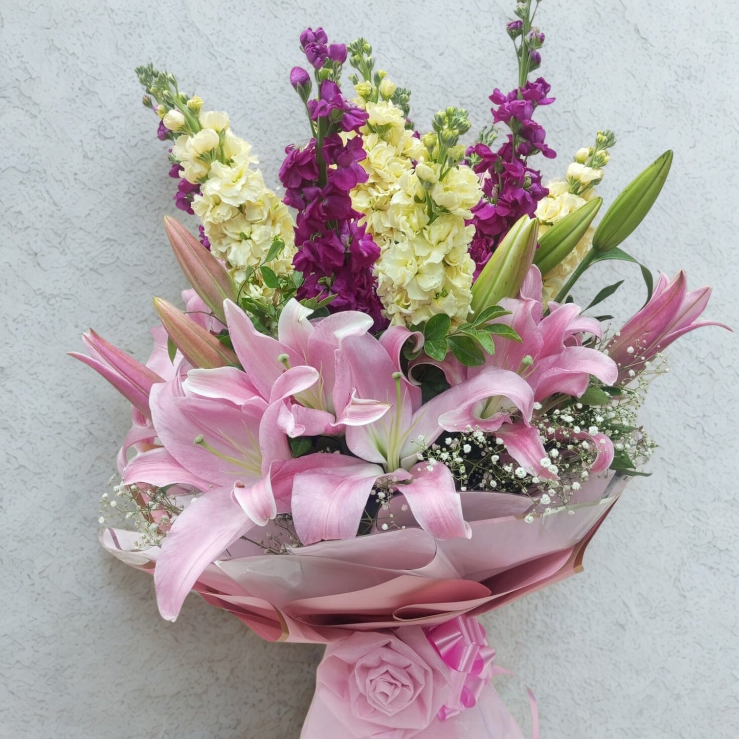 Elevate every moment with this regal blend of purple orchids, sunny yellow lilies, and graceful pink lilies. Vibrant and sophisticated, this bouquet adds instant grandeur and charm to any setting — a true showstopper.